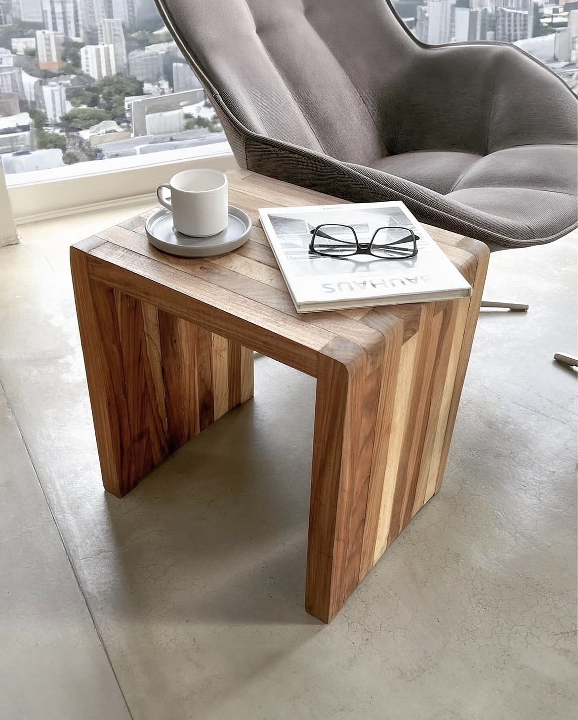 Tiendablau post, solid wood side table next to a contemporary chair